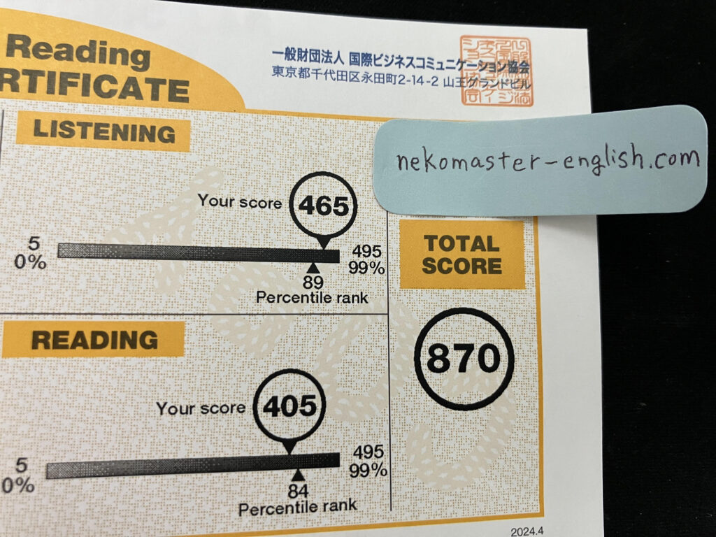 著者のTOEIC受験結果。Listening Part 465点、Reading Part 405点の合計870点。サイトのドメイン"nekomaster-english.com"と書かれた付箋がスコア証明書に直接貼られており、加工などによる偽物ではないことを表している。